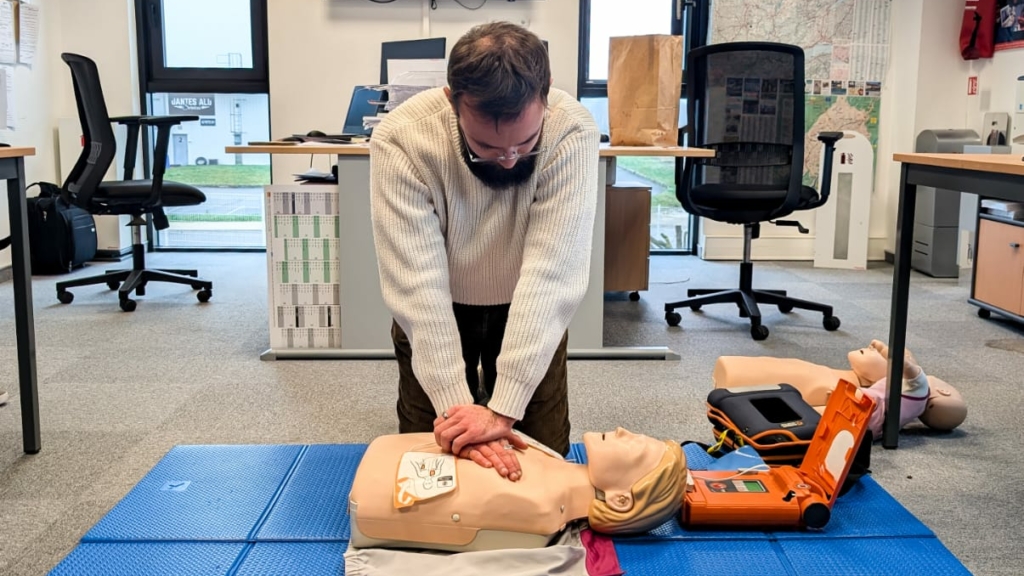 Elouan Fouchey, Chargé de développement chez Intermed, participant à l'exercice de massage cardiaque sur un mannequin à l'aide d'un défibrillateur.