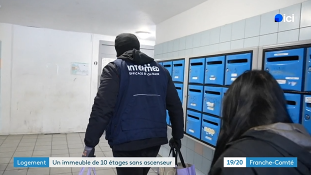 Capture d'&eacute;cran d'un reportage publi&eacute; par France 3 au sujet d'un immeuble en panne d'ascenseur &agrave; Besan&ccedil;on. On voit sur cette image un des salari&eacute;s d'INTERMED aider une r&eacute;sidente &agrave; porter ses courses.